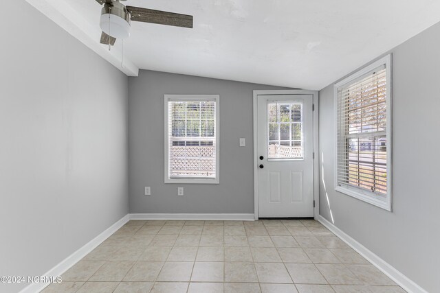 doorway to outside with lofted ceiling, light tile patterned floors, plenty of natural light, and ceiling fan