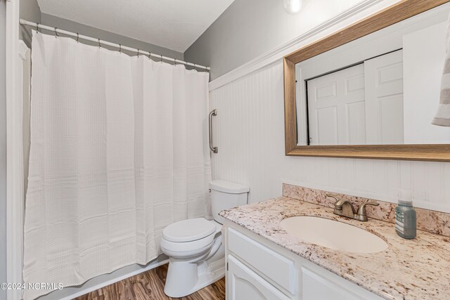 bathroom with vanity, toilet, wood-type flooring, and a shower with curtain