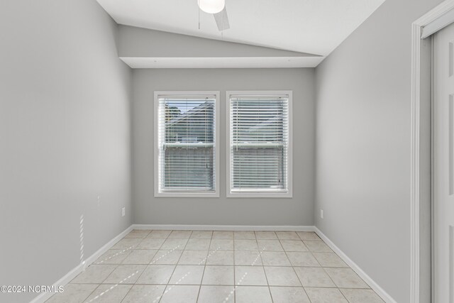 tiled empty room featuring lofted ceiling and ceiling fan