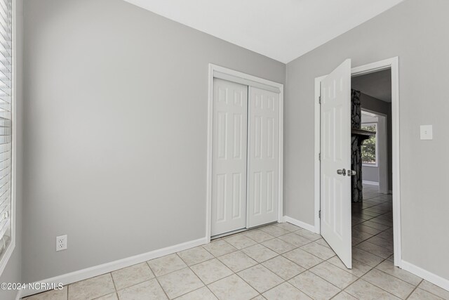 unfurnished bedroom featuring a closet and light tile patterned floors