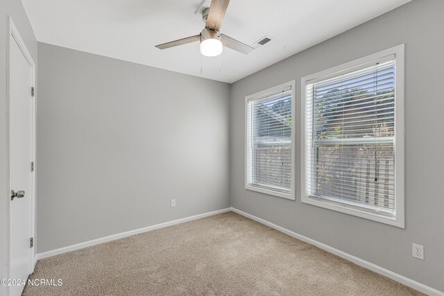 carpeted spare room featuring ceiling fan