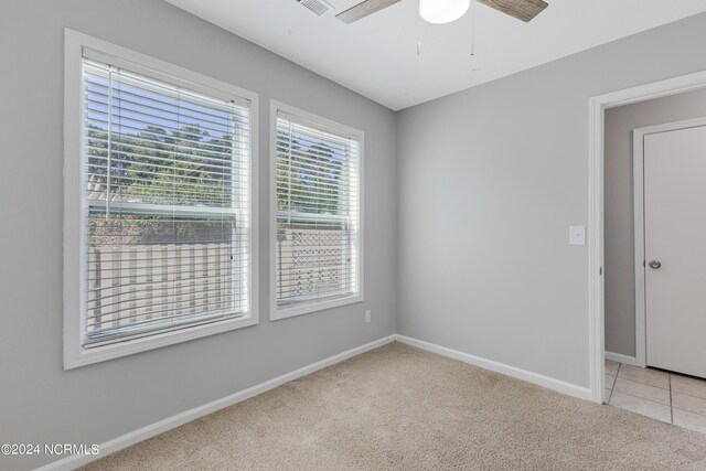 carpeted spare room with ceiling fan and plenty of natural light