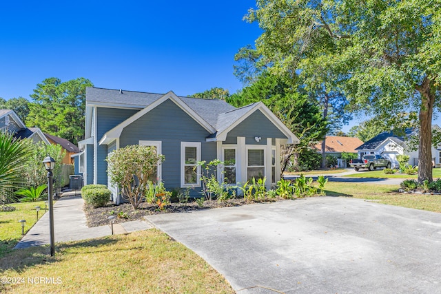 view of front of property with a front yard and central AC unit