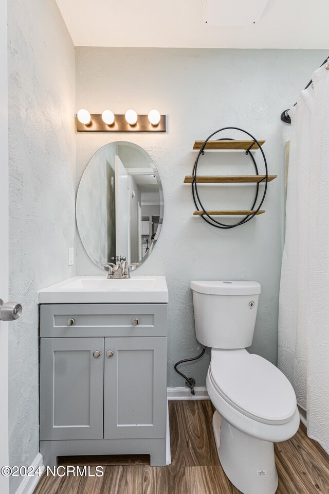 bathroom featuring vanity, a shower with curtain, wood-type flooring, and toilet