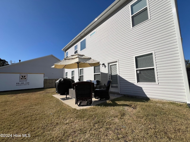 back of house with a patio area and a lawn