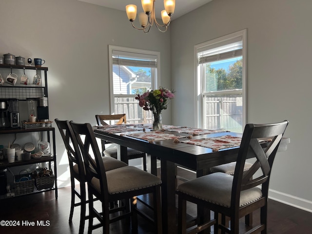 dining space with an inviting chandelier and dark hardwood / wood-style flooring