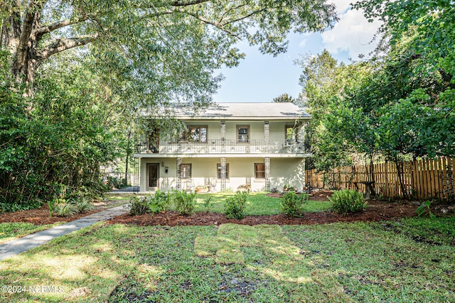 view of front of property with a balcony, a front yard, and a porch