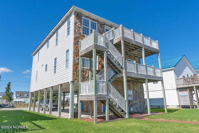 rear view of property with a deck, a patio, and a lawn