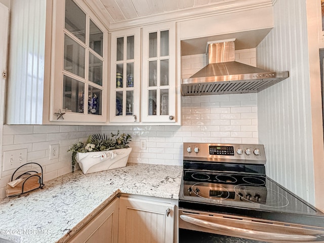 kitchen featuring tasteful backsplash, light brown cabinetry, stainless steel range with electric cooktop, and wall chimney exhaust hood