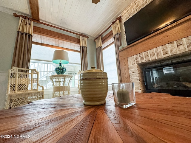 interior space featuring wood ceiling, ornamental molding, and a fireplace