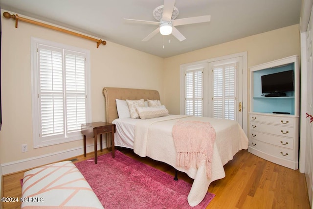 bedroom with multiple windows, ceiling fan, and light hardwood / wood-style floors