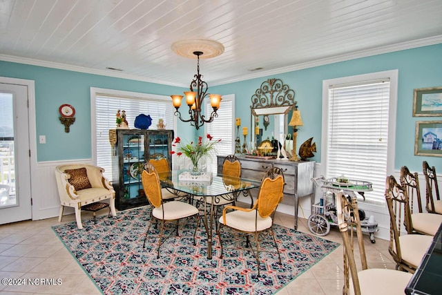 dining area with light tile patterned flooring, ornamental molding, a wealth of natural light, and a notable chandelier