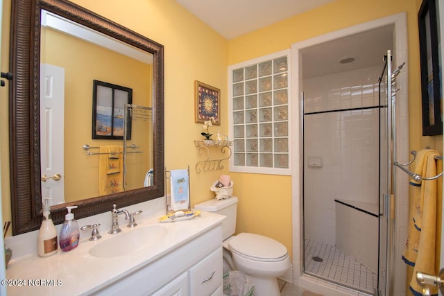 bathroom with vanity, a shower with door, and toilet