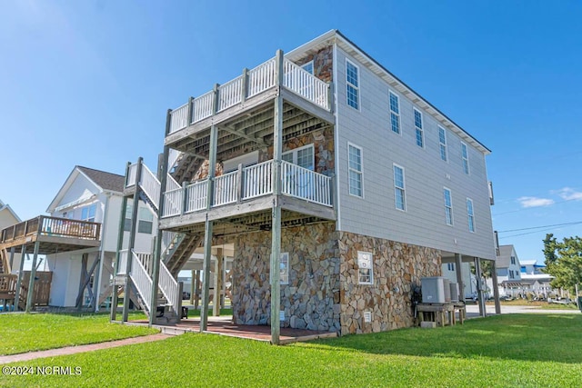 back of house featuring a wooden deck and a lawn