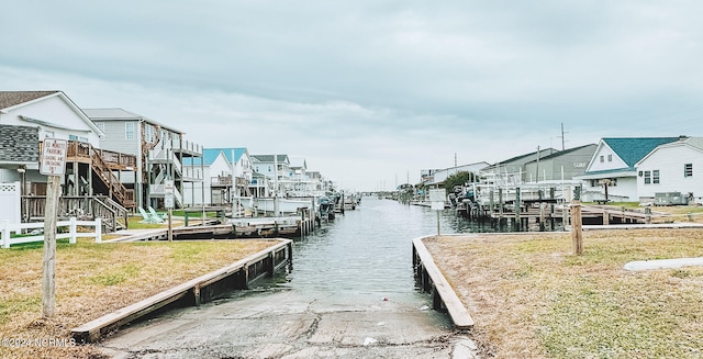 view of dock with a water view and a lawn