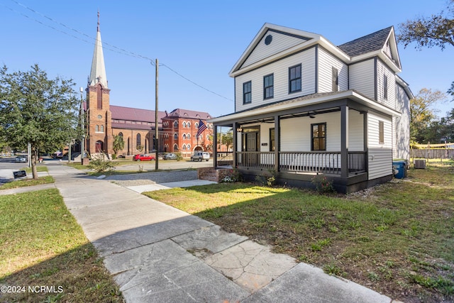 view of front of house featuring central AC, covered porch, and a front yard