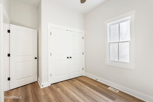 unfurnished bedroom featuring light hardwood / wood-style floors and a closet