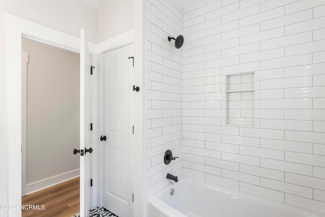 bathroom with wood-type flooring and tiled shower / bath