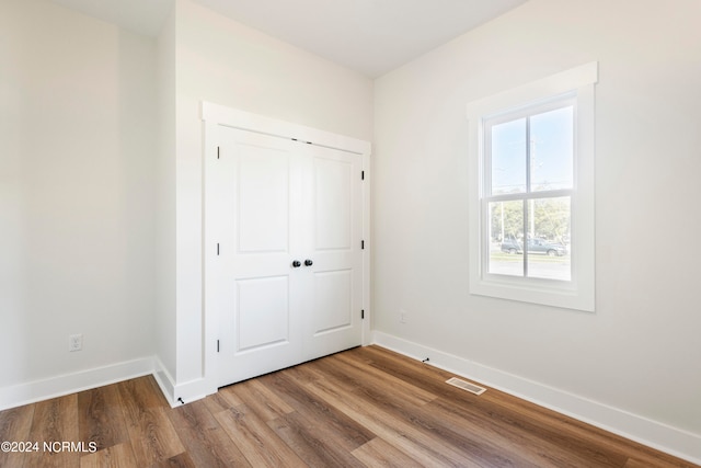 unfurnished bedroom with wood-type flooring and a closet