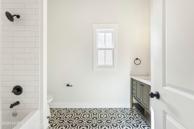 full bathroom featuring toilet, vanity, tiled shower / bath combo, and tile patterned flooring