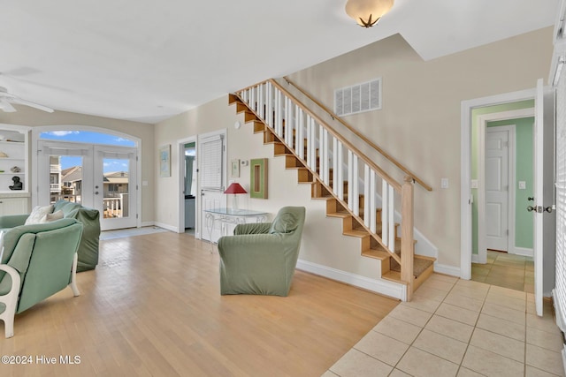 living room with french doors, ceiling fan, and light tile patterned flooring