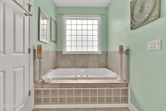 bathroom with tile patterned flooring and a relaxing tiled tub