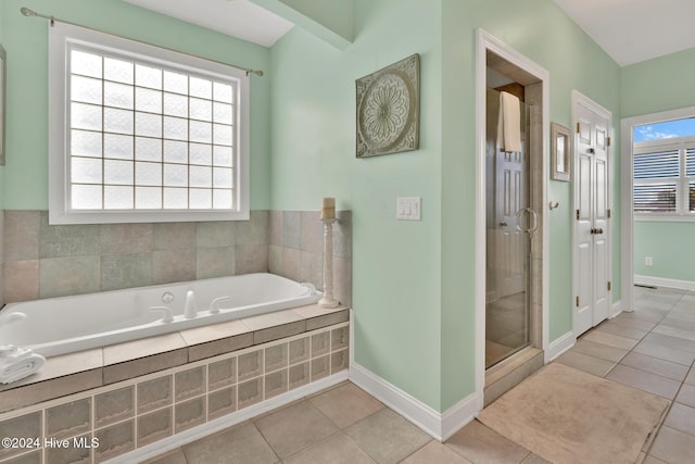 bathroom with tile patterned flooring and shower with separate bathtub