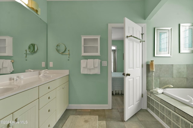 bathroom featuring tile patterned flooring, vanity, and a relaxing tiled tub