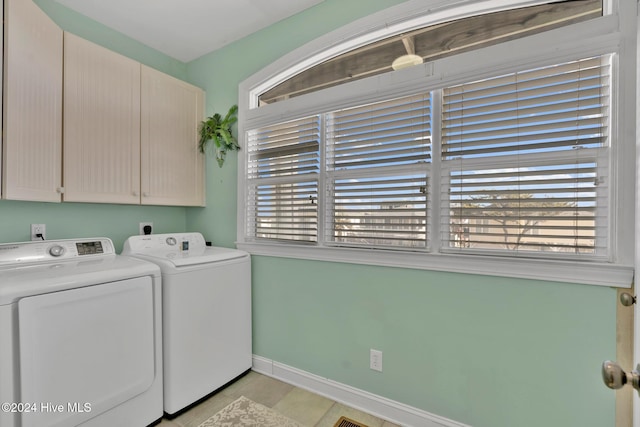 laundry room featuring cabinets, light tile patterned floors, and separate washer and dryer