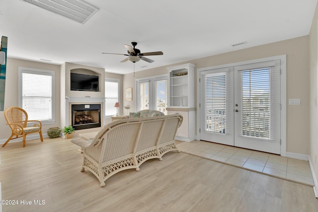 living room featuring french doors, ceiling fan, plenty of natural light, and light hardwood / wood-style flooring