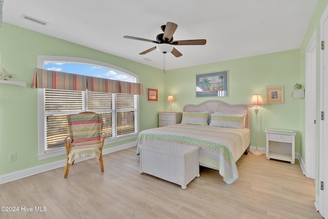 bedroom with multiple windows, light hardwood / wood-style flooring, and ceiling fan