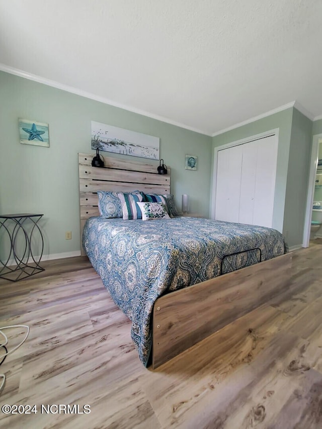 bedroom featuring a closet, crown molding, and light hardwood / wood-style flooring