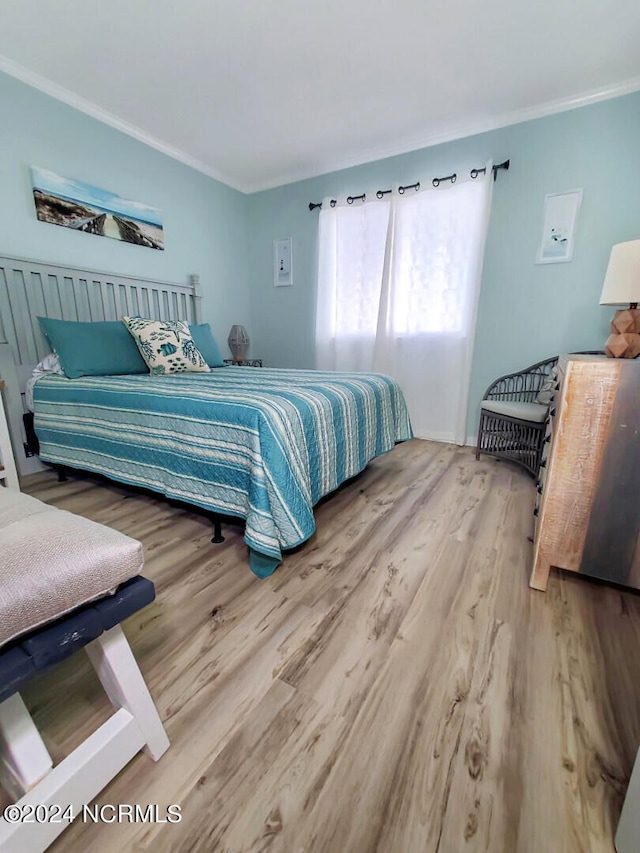 bedroom featuring ornamental molding and hardwood / wood-style flooring