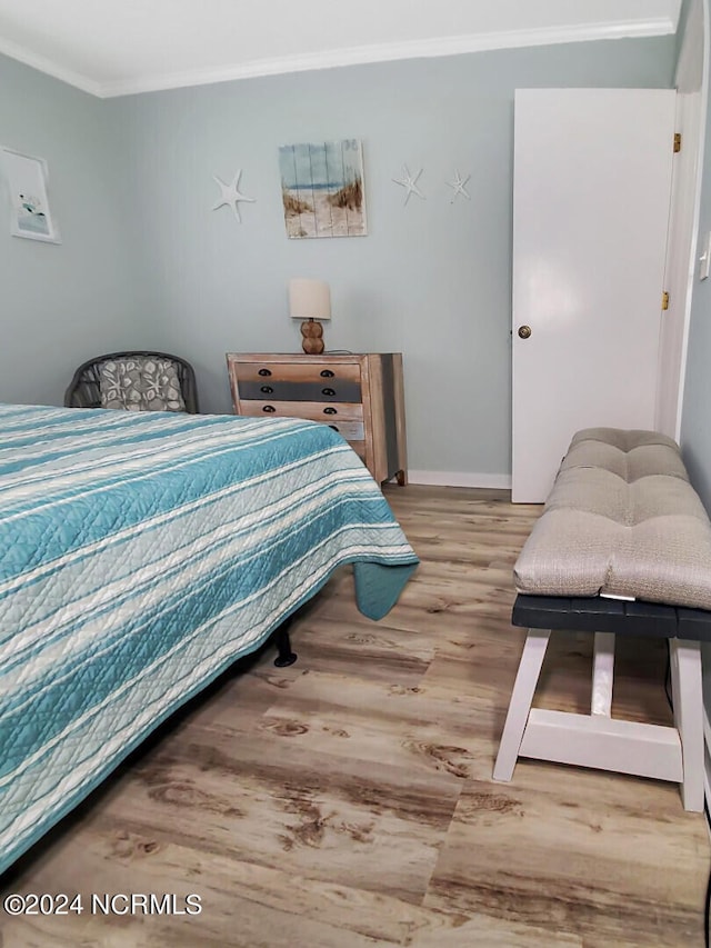 bedroom with hardwood / wood-style flooring and crown molding