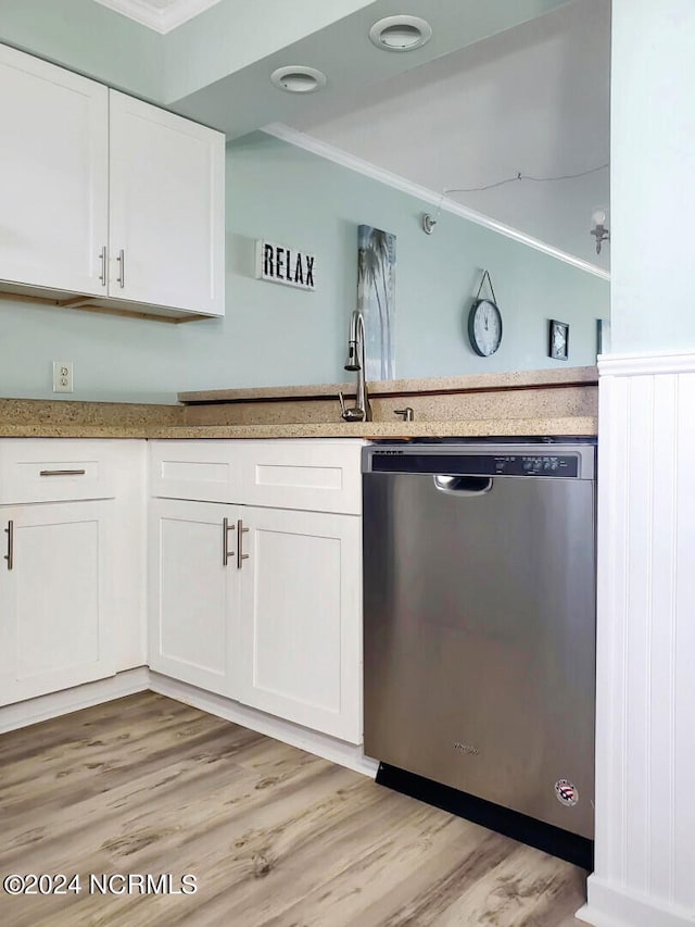 kitchen featuring white cabinets, sink, ornamental molding, stainless steel dishwasher, and light wood-type flooring