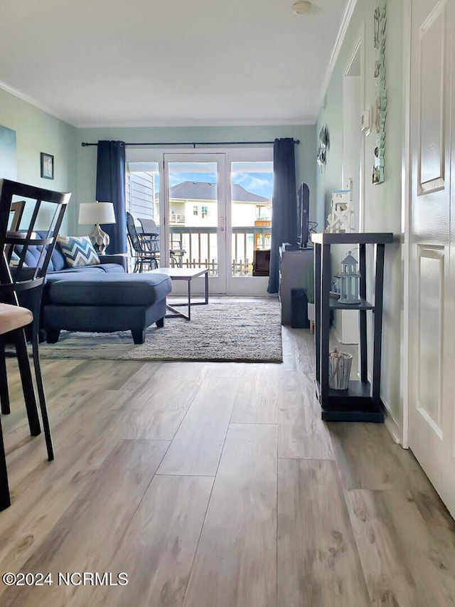 living room with ornamental molding and light hardwood / wood-style floors