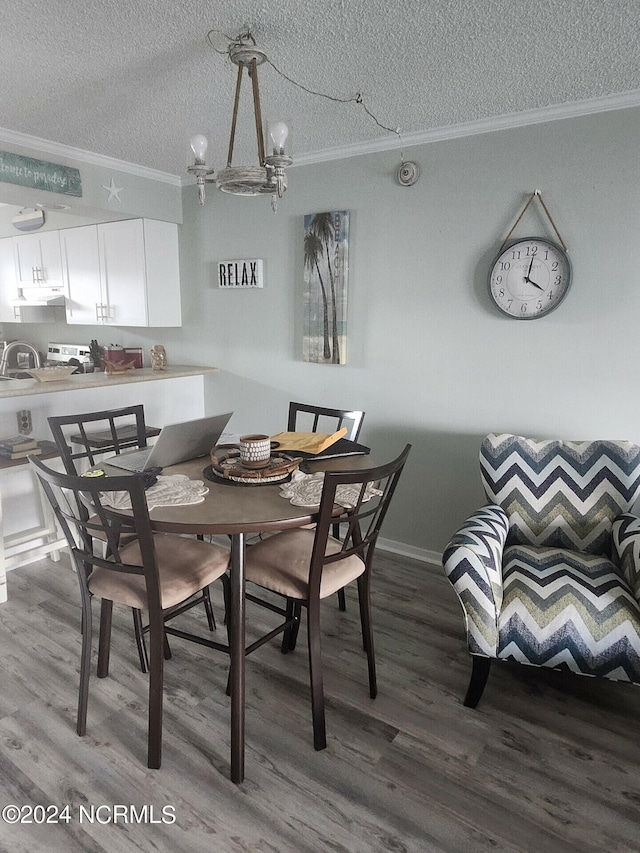 dining space with a textured ceiling, crown molding, hardwood / wood-style floors, and a chandelier