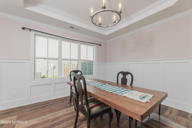 dining area with crown molding, a tray ceiling, and dark hardwood / wood-style flooring