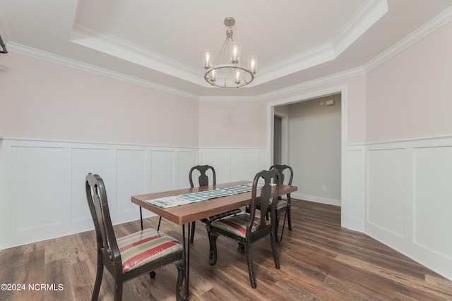 dining area with a raised ceiling, ornamental molding, and dark hardwood / wood-style flooring