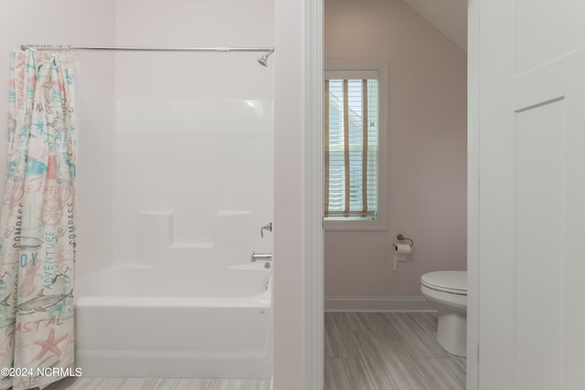 bathroom featuring toilet, wood-type flooring, lofted ceiling, and shower / bath combo