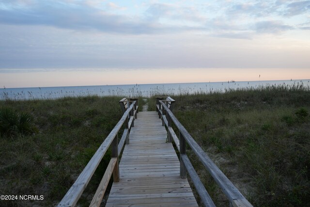 dock area featuring a water view and a beach view