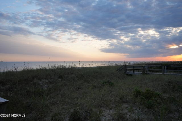 yard at dusk featuring a water view