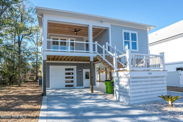 view of front facade featuring a porch, a garage, central AC unit, and ceiling fan