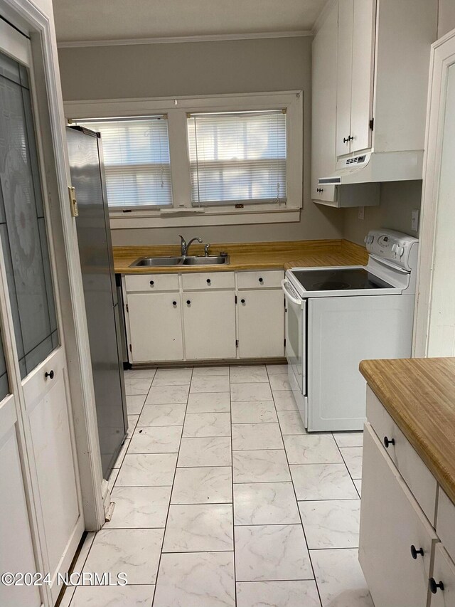 kitchen featuring a healthy amount of sunlight, electric range, sink, and white cabinetry