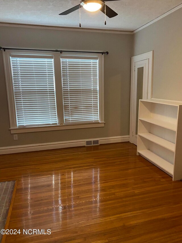 unfurnished room featuring wood-type flooring, ornamental molding, a textured ceiling, and ceiling fan