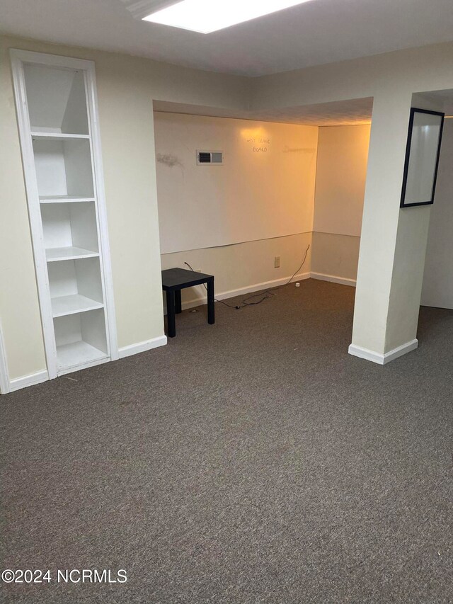 basement featuring dark colored carpet