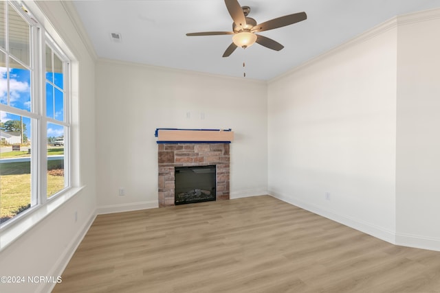 unfurnished living room with ceiling fan, ornamental molding, light hardwood / wood-style flooring, and a fireplace