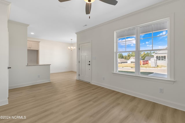 empty room featuring ornamental molding, light wood-type flooring, and ceiling fan with notable chandelier