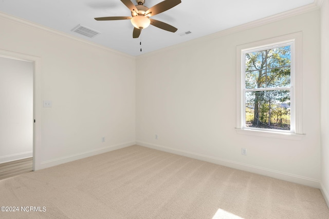 empty room with ceiling fan, light carpet, and ornamental molding