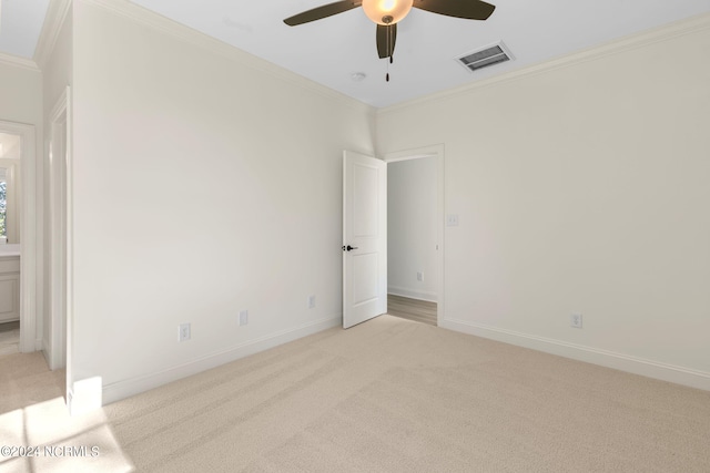 empty room with ornamental molding, light carpet, and ceiling fan